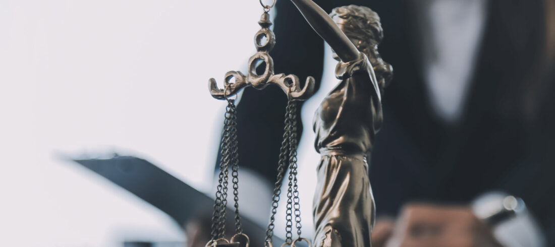 Business and lawyers discussing contract papers with brass scale