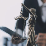 Business and lawyers discussing contract papers with brass scale